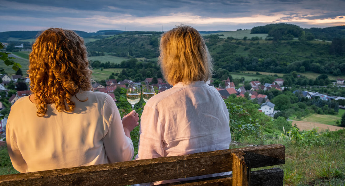 zwei Frauen auf einer Bank bei Deammerung